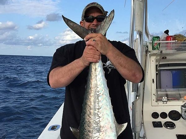 Man holding up catch on boat